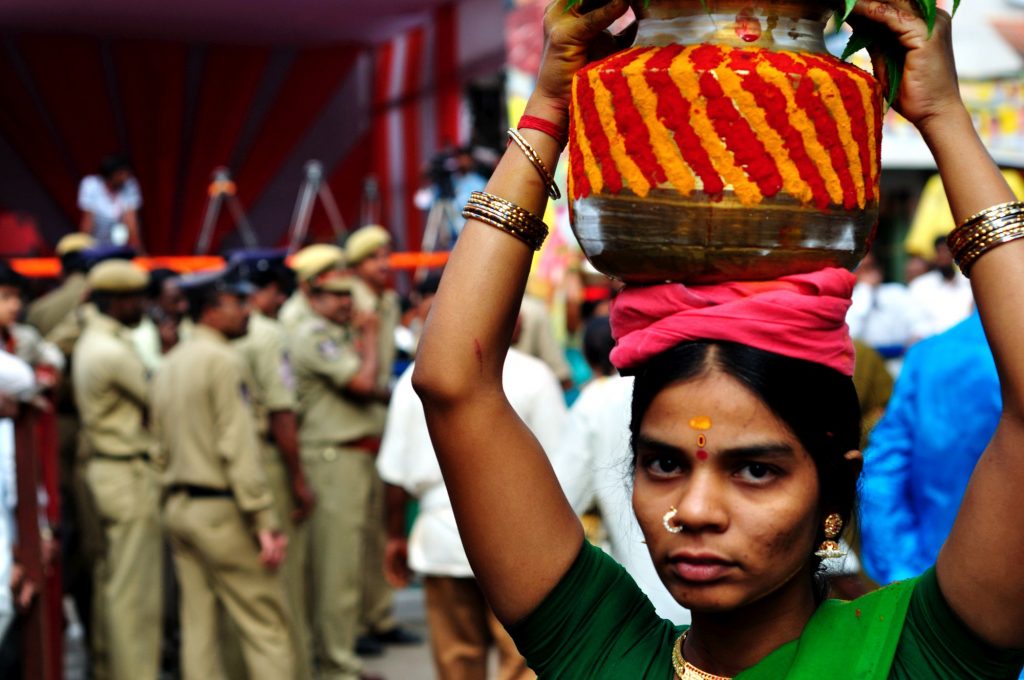 Polices are seen as a devotee carries her offering. The police and RAF (Rapid Action Force) are delegated to maintain the crowd and to avoid any unwanted commotion during the festival.