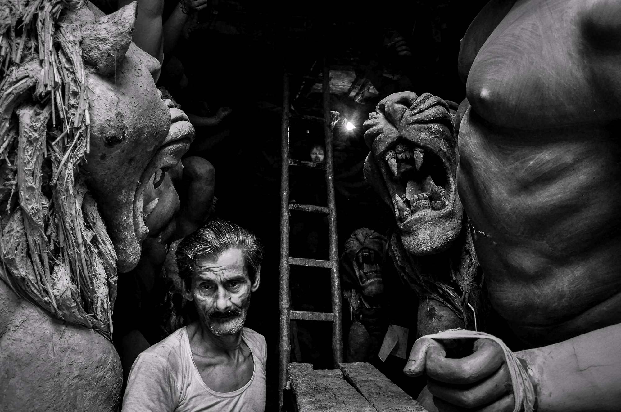 A man walks in between the idols in one of the workshops at Kumartuli