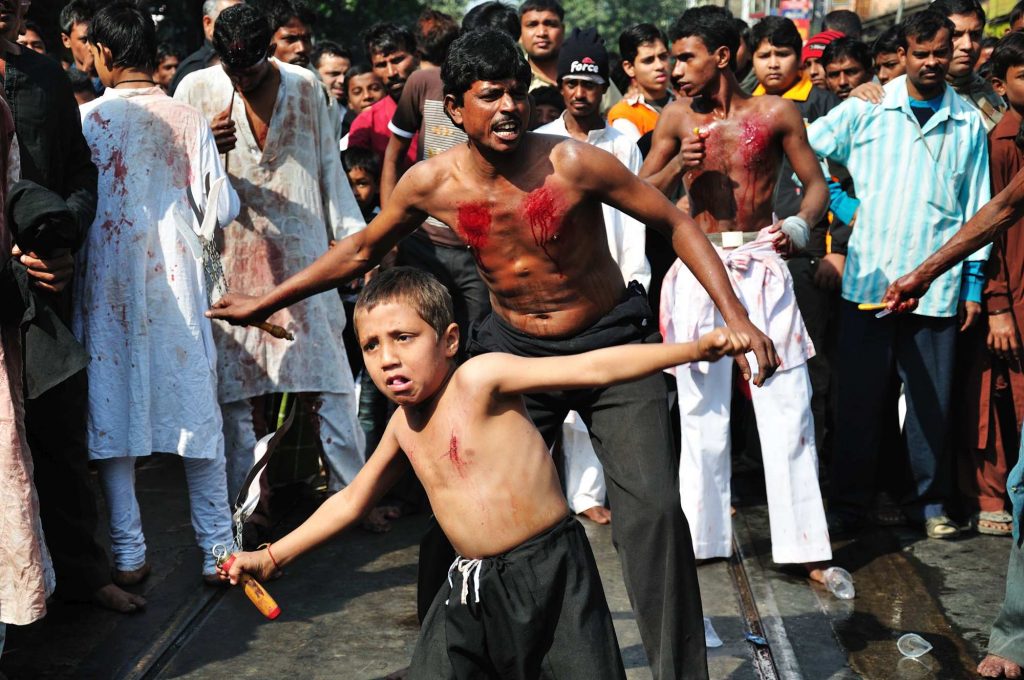 Kids along with the adults taking part in the act hitting onself with knives to commemorate the tragic history of the day.