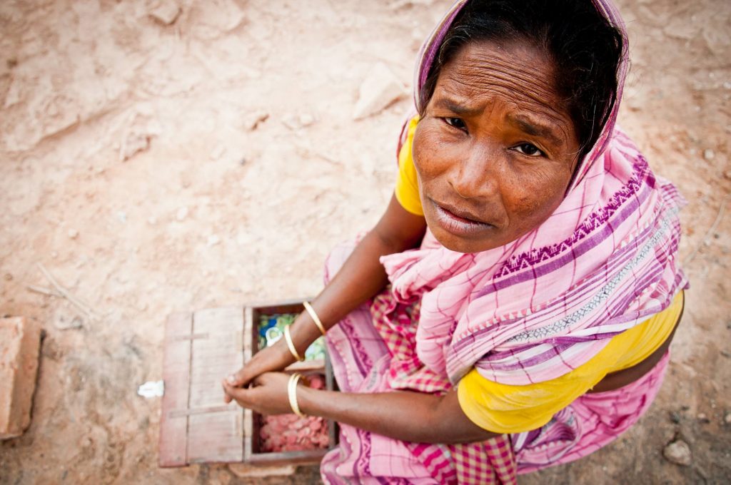 A women pays tokens to the worker each time they carry the bricks to the storage area